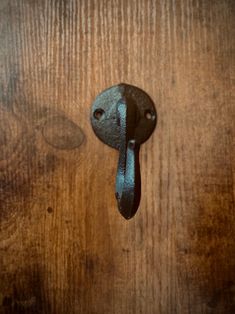 an old door handle on the side of a wooden door that has been painted black