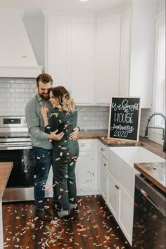 a man and woman standing in a kitchen with confetti falling from the ceiling