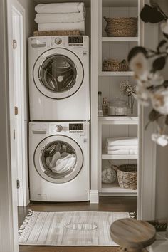 a washer and dryer in a small room with open shelving on the wall