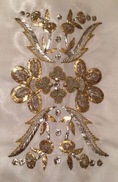 an embroidered white cloth with gold and silver flowers