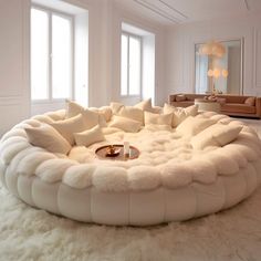 a large white circular couch sitting on top of a fluffy rug in a living room