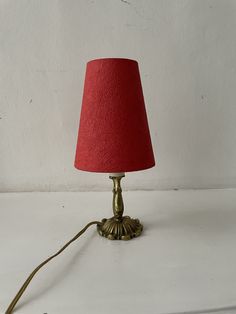 a red lampshade sitting on top of a white table