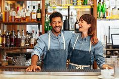 a man and woman standing behind a bar