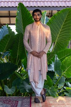 For day-long wedding festivities, a dapper muted pink kurta set from Bohame is a must-have. The exquisite thread embroidery and eye-catching mirror work amplifies this charming outfit, ensuring it captures hearts. Explore more from the label at our website from an exclusive curation, Baraat: The Groom's Edit. #Perniaspopupshopmen #menswear #ethnic #whatiworewastrending #ppuslove #Bohame #kurtaset Haldi Dress For Groom, Groom Indian Wedding Outfits, Traditional Indian Mens Clothing, Man Dress Design, Sherwani For Men Wedding