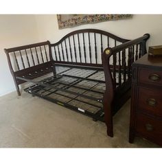 a wooden bed frame sitting on top of a carpeted floor next to a dresser