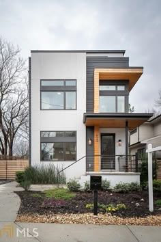 a modern house with lots of windows and landscaping