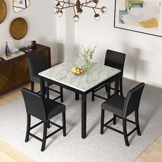 a dining table with four chairs and a marble top