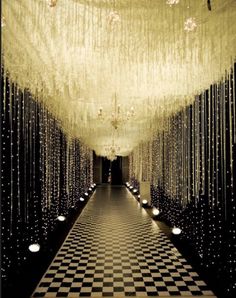 a black and white checkerboard floor with chandeliers hanging from the ceiling