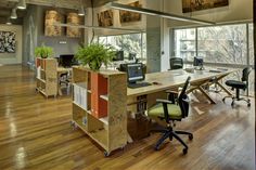 an office with wooden floors and large windows