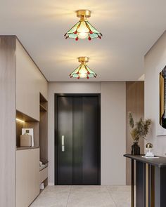 a hallway leading to a bathroom with two lights on the ceiling and an open door