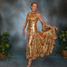 will fit size 5/6-9/10...5'6" or taller Be the envy of the dance floor with this stunning Gold Hologram Tango-Paso Doble Dress! Crafted of golden iridescent hologram tiger print lycra, this elegant ensemble boasts lots of flounces, a long sleeve with a peak at the wrist, and shimmering accents courtesy of volcano colored Swarovski rhinestones, which shine several different shades including purple & yellow. Make a statement with two thigh-high slits in the front, and show off your amazing tango Spanish Princess, Spanish Dress, Tango Dress, Dance Costume, Tiger Print, The Dance, Dance Floor, Volcano, Tango