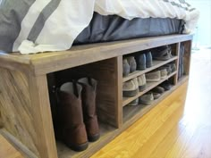 a wooden shoe rack with several pairs of shoes on it and a yellow blanket over the top