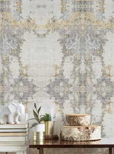 a table topped with two vases filled with flowers next to a wall covered in textured paper