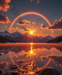 the sun is setting over a lake with mountains in the background and clouds reflected in the water