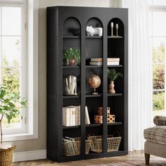 a black bookcase with baskets and books on it