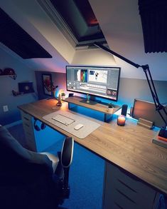 a desk with a computer monitor, keyboard and mouse on it in a dark room