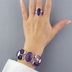 This elongated amethyst ring makes all kinds of sense: it is big enough to be seen, bold enough to steal looks, and versatile enough to be in anyone’s jewelry box. Gemstone - Genuine Amethyst 925 Sterling silver High polish finish Approx. 0.8" L x 0.45" W Adjustable size Signed by the artist Handmade in Taxco, Mexico Modern Oval Purple Jewelry, Modern Purple Oval Jewelry, Elegant Purple Amethyst Ring With Large Stone, Elegant Purple Amethyst Ring Oval Cabochon, Elegant Purple Oval Cabochon Amethyst Ring, Modern Purple Amethyst Ring With Polished Finish, Modern Purple Rings With Polished Finish, Modern Polished Amethyst Ring, Modern Purple Amethyst Rings