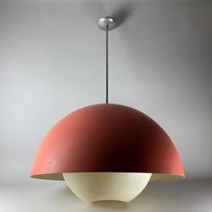 a red and white lamp hanging from a ceiling