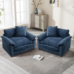 two blue chairs sitting on top of a rug