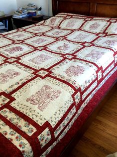 a red and white quilted bedspread on top of a wooden bed frame