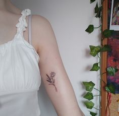 a woman's arm with a flower tattoo on the left side of her arm