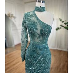 Striking turquoise color exudes vibrancy and elegance. One-shoulder design adds a touch of sophistication. Mermaid silhouette accentuates curves for a flattering fit. Adorned with intricate beadwork for a glamorous look. Perfect for women's wedding parties and formal events. Crafted with high-quality materials for comfort and durability. Embodies grace and style for a memorable occasion. Green Fitted Evening Dress With Asymmetrical Neckline, Fitted Green Evening Dress With Asymmetrical Neckline, Green Fitted Gown With Asymmetrical Neckline, Elegant Turquoise Evening Gown, Floor-length Turquoise Gown For Party, Turquoise Floor-length Gown For Party, Elegant Floor-length Turquoise Gown, Elegant Turquoise Floor-length Evening Dress, Elegant Turquoise Floor-length Gown