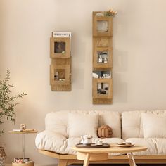 a living room with white couches and wooden shelves on the wall above them,