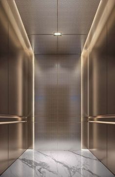 an empty elevator with no doors and lights on the walls, in front of a marble floor