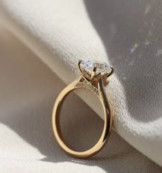 a diamond ring sitting on top of a white cloth