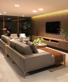 a living room with couches and a television on the wall in front of it