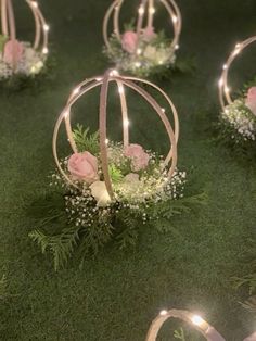 some flowers and lights are placed in small balls on the grass with string lights around them