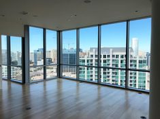 an empty room with large windows overlooking the city