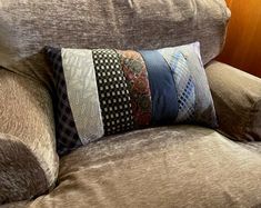 a close up of a couch with pillows on it's back and the pillow is made out of fabric