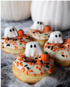 halloween donuts decorated with white icing and sprinkles in the shape of ghostes