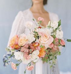 a woman holding a bouquet of flowers in her hands