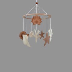 a mobile with shells and starfishs hanging from it's sides on a gray background