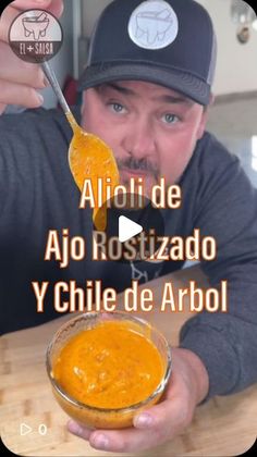 a man holding a spoon full of orange sauce in front of his face with the words aloii de ao rositzado y chile de arbol