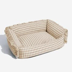 a brown and white checkered dog bed with ruffles on the bottom part