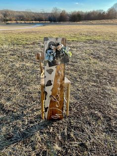 a wooden chair decorated with flowers in the middle of a field