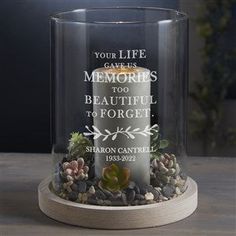 a clear glass candle with an inscription on it