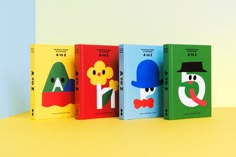 three books with cartoon characters on them are lined up against a yellow background, the first one has a blue hat