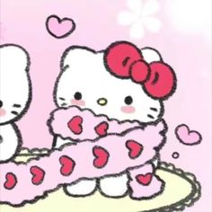 two hello kitty sitting on top of a cake with pink frosting and hearts around it