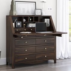 a wooden desk with drawers and a laptop on it