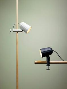 a desk lamp sitting on top of a wooden table next to a light pole with a spotlight