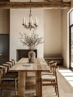 a dining room table with chairs and a vase filled with flowers on top of it