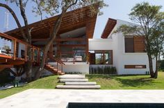 a modern house with stairs leading to the upper floor and second story, overlooking a swimming pool