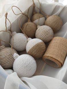 white and beige balls are tied to twine in a box with burlap