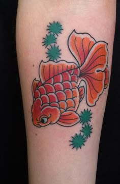 an orange and green fish tattoo on the leg