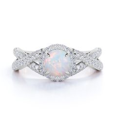 a white opal and diamond ring on a white background