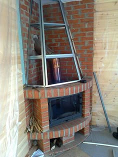 a brick fireplace being built in the corner of a room with a ladder leaning against it